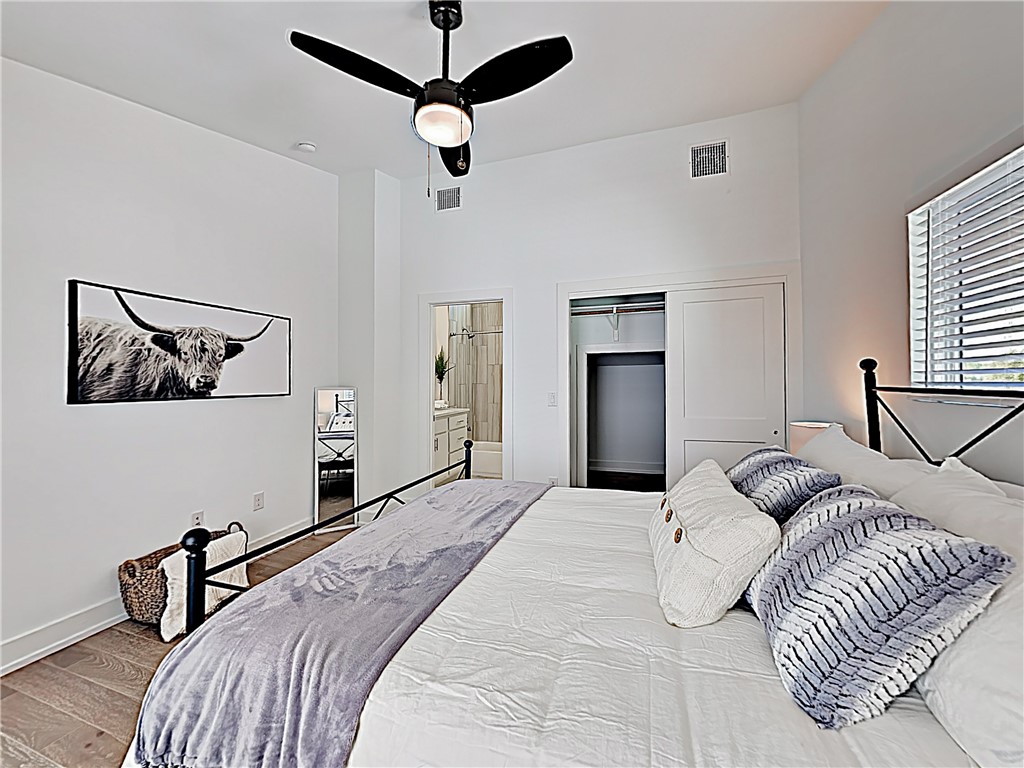 5314 Downs Drive, Unit A Austin, TX 78721 - Photo 16 of 19 a bedroom with a large bed and a ceiling fan