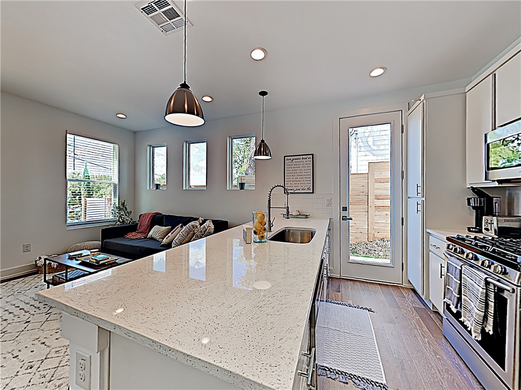 5314 Downs Drive, Unit A Austin, TX 78721 - Photo 5 of 19 a very nice looking dining room with kitchen island furniture a window a sink and a refrigerator