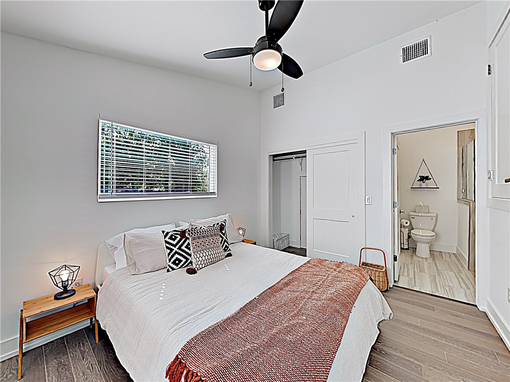 5314 Downs Drive, Unit A Austin, TX 78721 - Photo 9 of 19 a bedroom with a bed and wooden floor