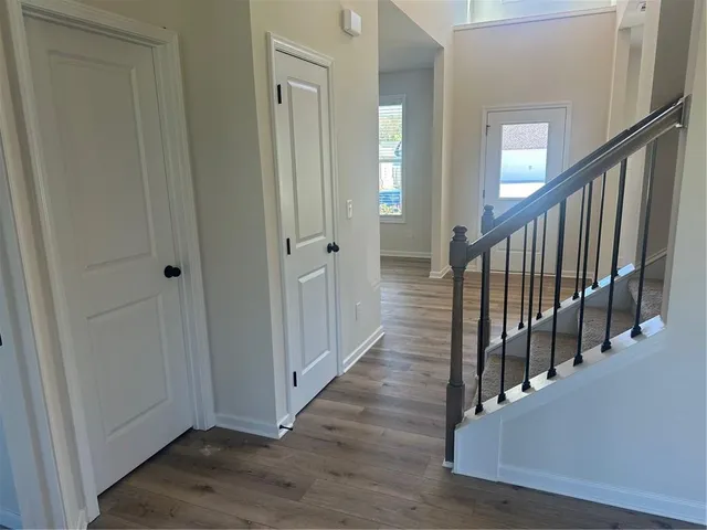 a view of a hallway with wooden floor and staircase