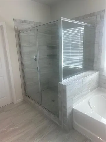 a bathroom with a bathtub a shower and a sink