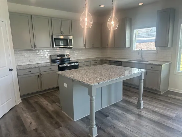 a kitchen with a sink cabinets and wooden floor
