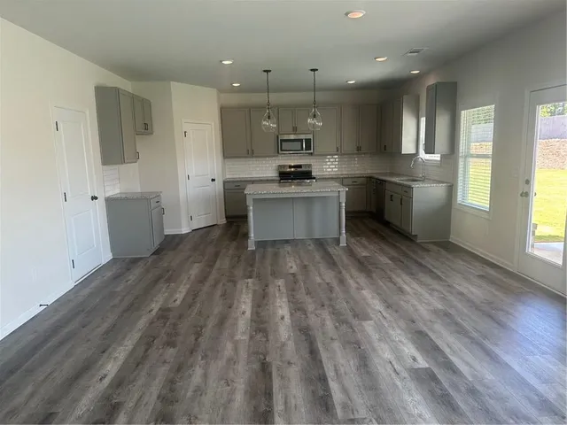 a large kitchen with a lot of counter space and stainless steel appliances