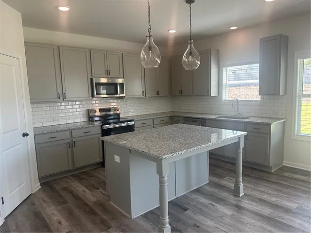 a kitchen with a stove cabinets and wooden floor