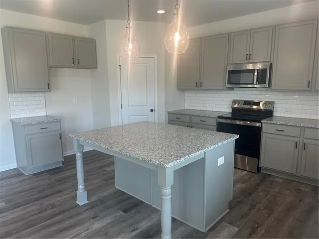 a kitchen with a stove a sink and a microwave