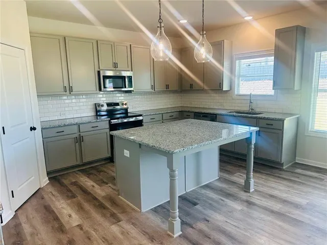 a kitchen with stainless steel appliances granite countertop a sink stove and refrigerator