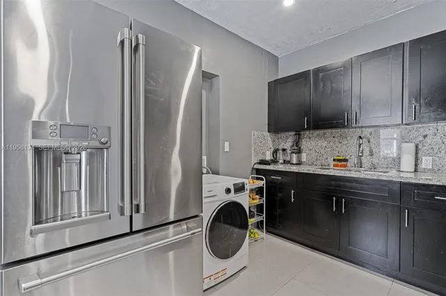a kitchen with stainless steel appliances granite countertop a sink and a refrigerator
