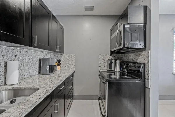 a kitchen with granite countertop stainless steel appliances and a counter top space