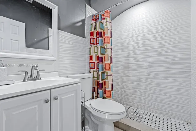 a bathroom with a sink a toilet and shower curtain