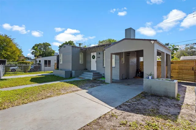 a front view of a house with a yard and potted plants