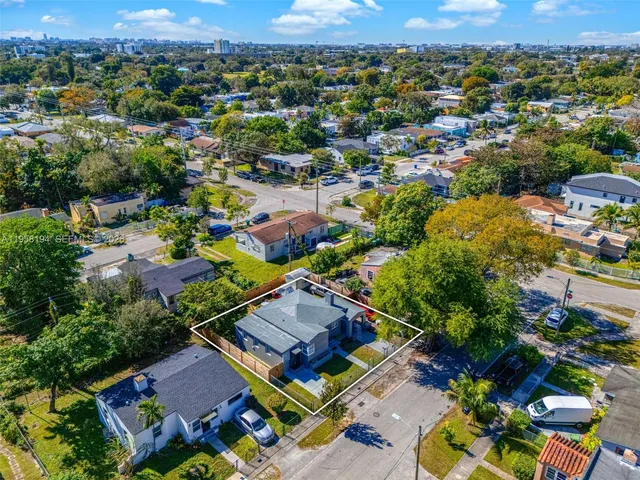 an aerial view of residential houses with outdoor space and trees