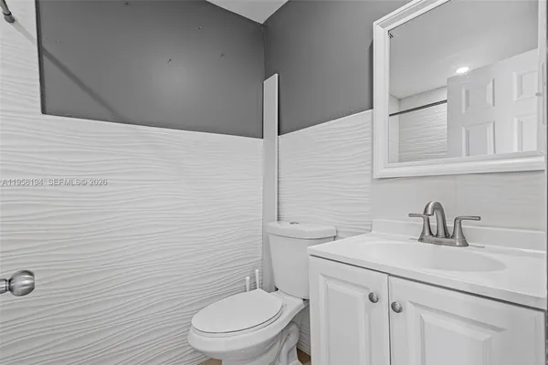 a bathroom with a toilet a sink and mirror