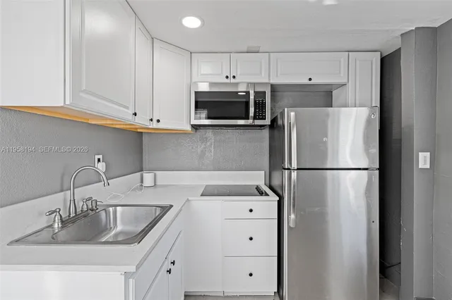 a kitchen with refrigerator and cabinets