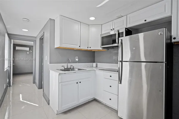 a kitchen with cabinets a refrigerator and a sink