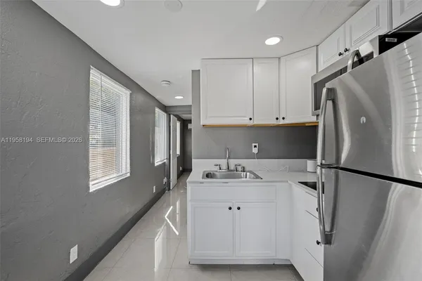 a kitchen with stainless steel appliances granite countertop a refrigerator sink and cabinets