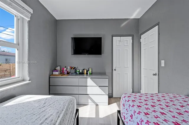 a bedroom with a bed a flat screen tv and view of living room