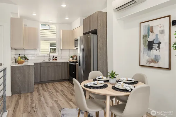 a kitchen with stainless steel appliances granite countertop a sink a stove a refrigerator with a dining table and chairs