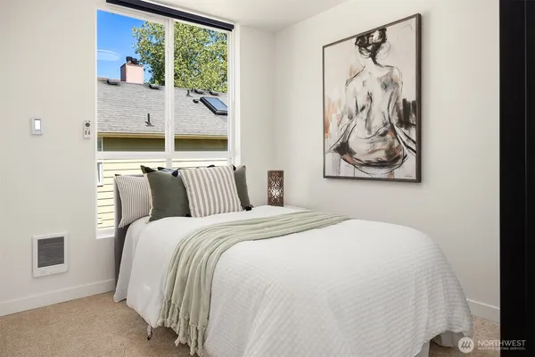 a bedroom with bed and wall painting with large window