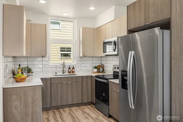 a kitchen with stainless steel appliances a refrigerator a sink a stove and cabinets