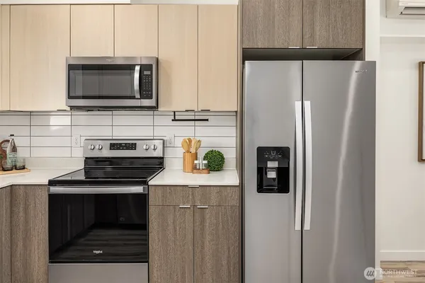 a kitchen with stainless steel appliances a refrigerator stove and microwave