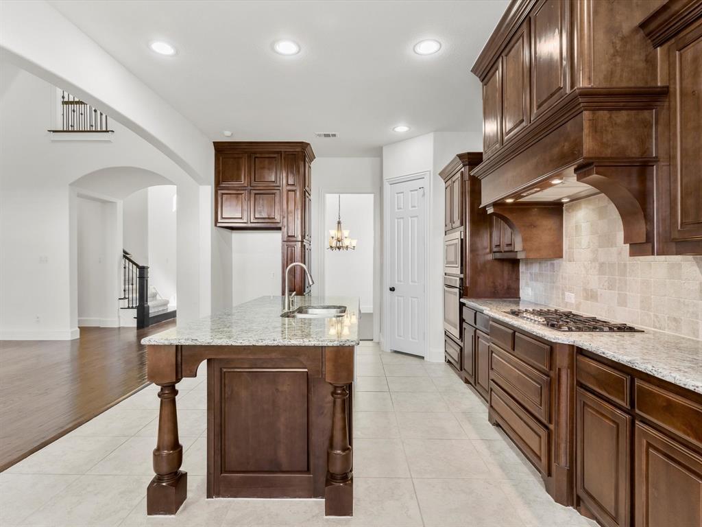13192 Mapleton Drive Frisco, TX 75035 - Photo 11 of 40 a kitchen with stainless steel appliances granite countertop a stove a sink and a refrigerator