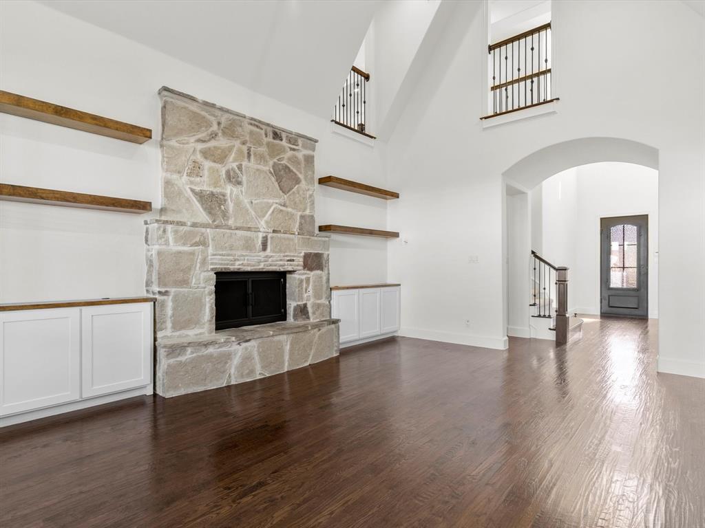13192 Mapleton Drive Frisco, TX 75035 - Photo 16 of 40 an empty room with wooden floor and a fireplace