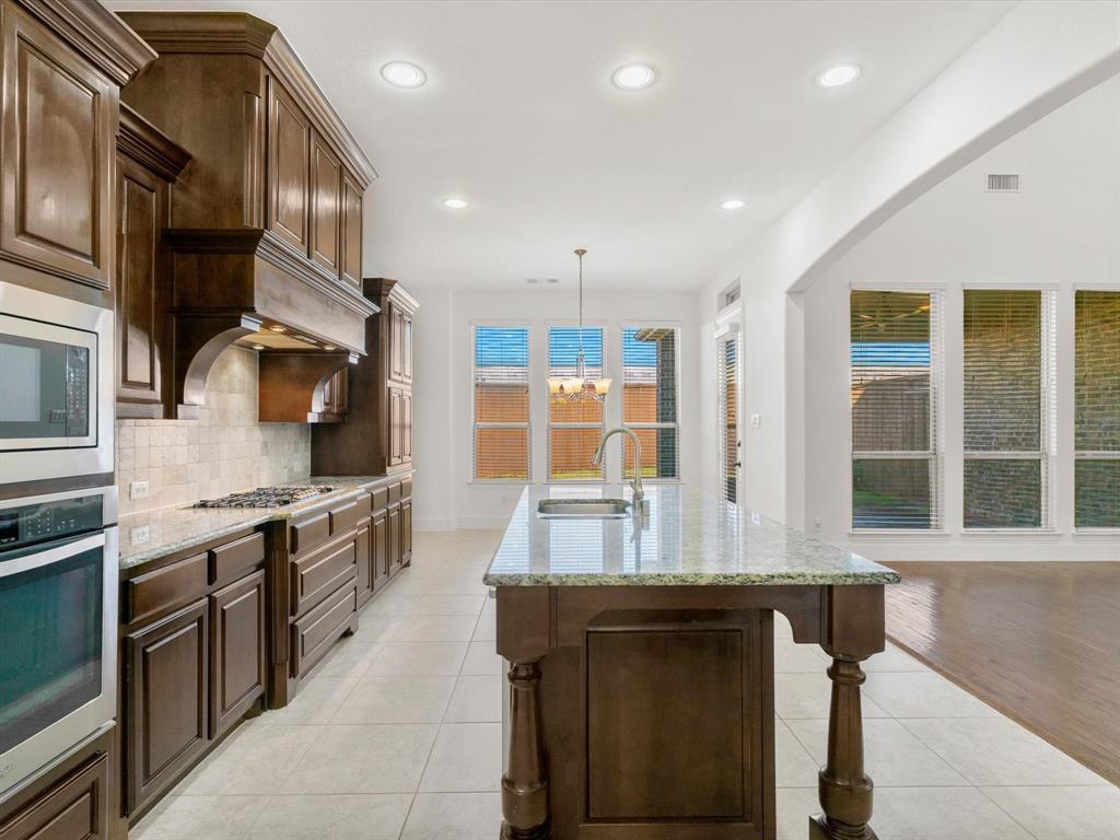 13192 Mapleton Drive Frisco, TX 75035 - Photo 9 of 40 a kitchen with stainless steel appliances granite countertop a sink stove and refrigerator