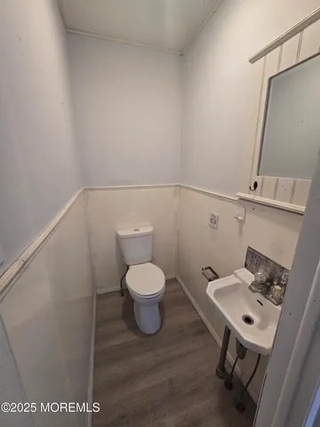 a bathroom with a toilet sink and a mirror