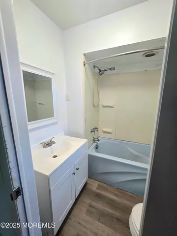 a bathroom with a tub sink toilet and mirror
