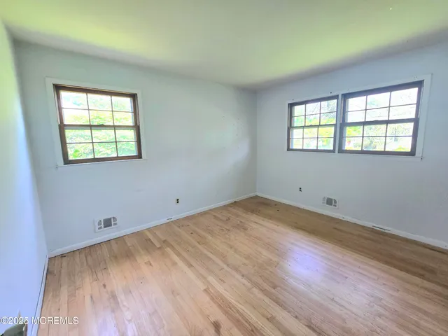 a view of a room with wooden floor and window
