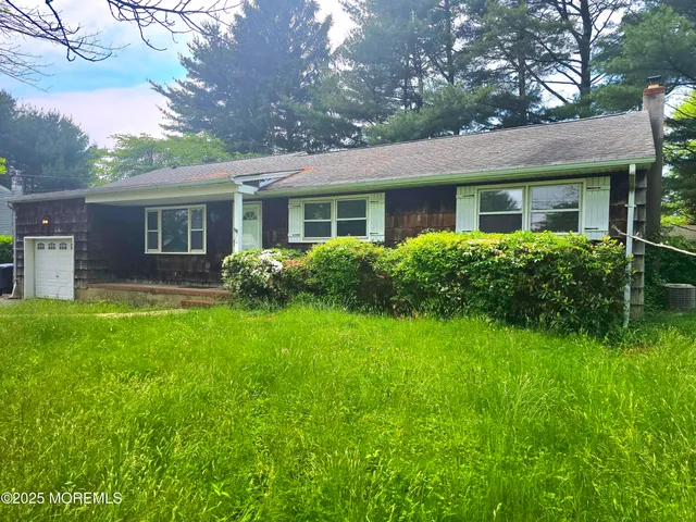 a view of a house with a yard and potted plants
