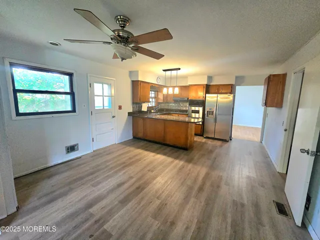 a view of a kitchen with a sink refrigerator and wooden floor