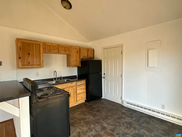 a kitchen with granite countertop a refrigerator and a stove top oven