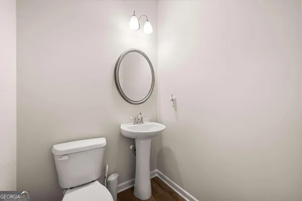 a bathroom with a toilet a sink and a mirror