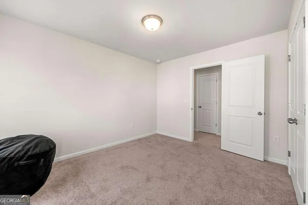 an empty room with a chair and a potted plant