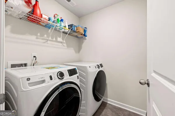 a view of washer and dryer with kitchen in the background