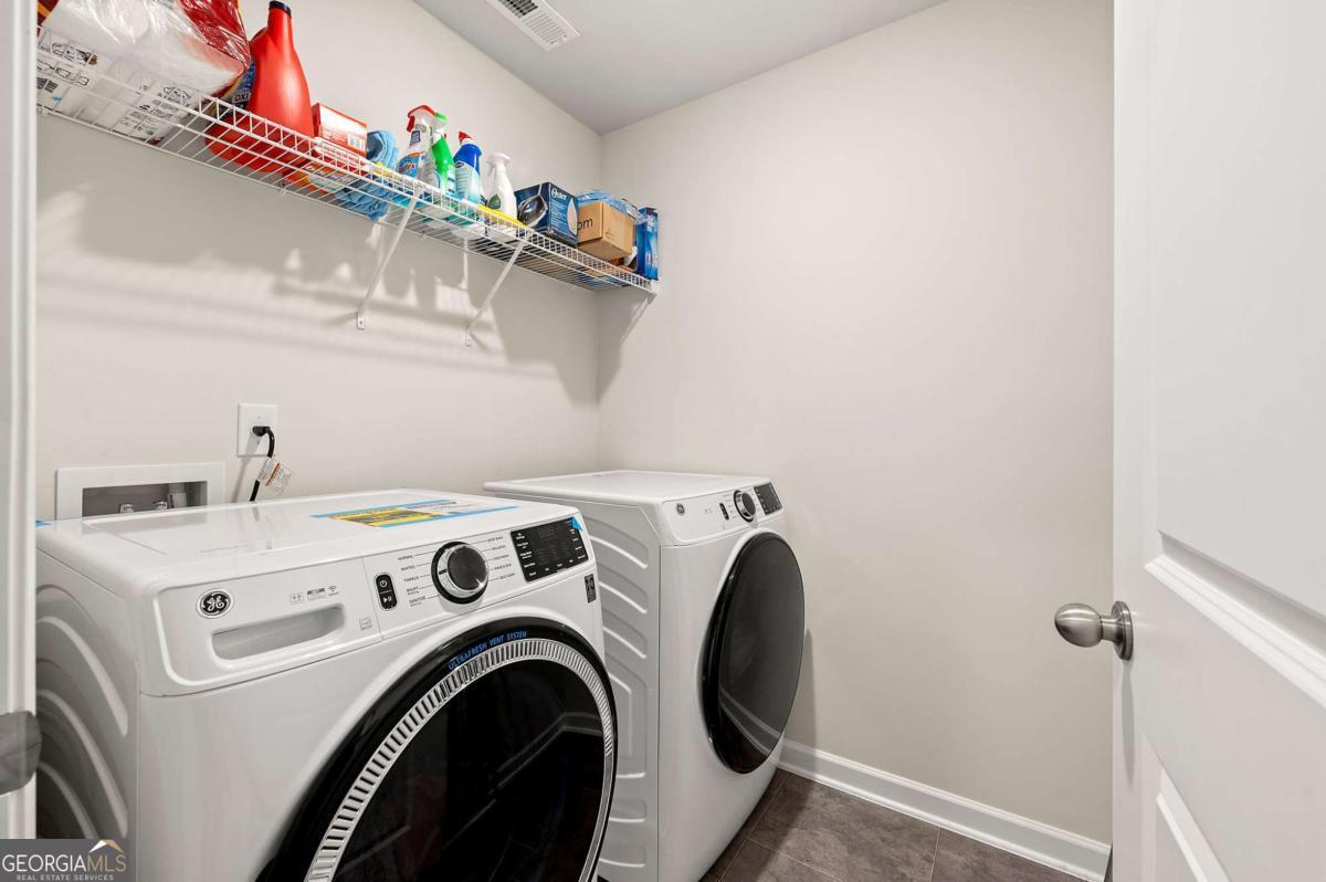 6372 Rosetta Drive Atlanta, GA 30331 - Photo 18 of 26 a view of washer and dryer with kitchen in the background
