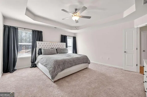 a bedroom with a large bed and a ceiling fan