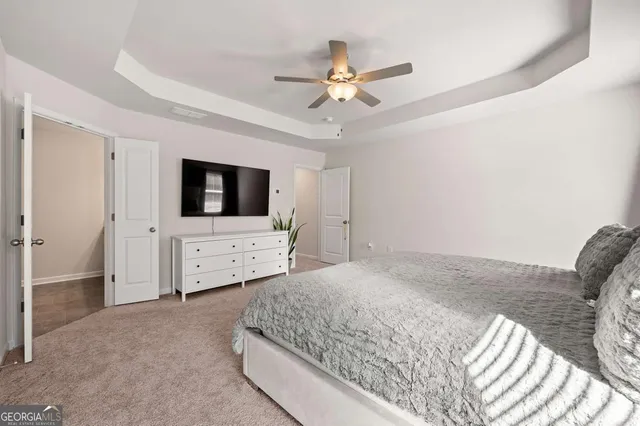 a bedroom with a bed and a flat tv screen on dresser