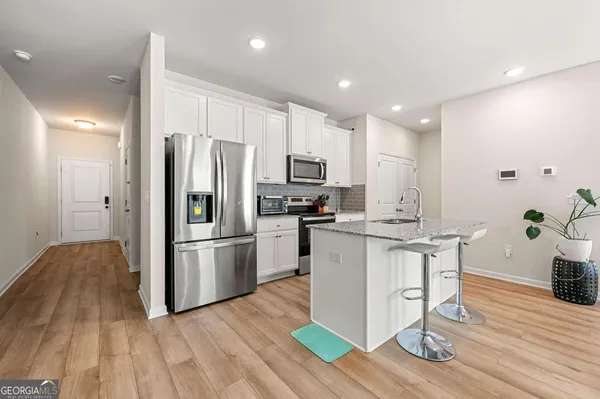 a kitchen with granite countertop a refrigerator and a stove top oven