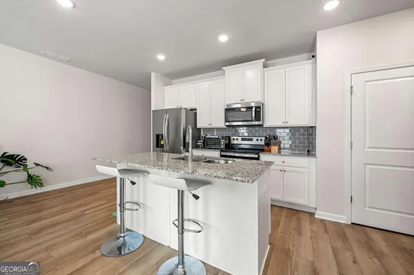 a kitchen with a sink a microwave a refrigerator and cabinets