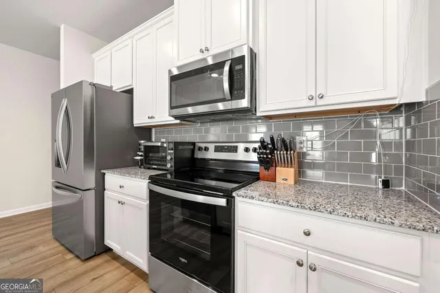 a kitchen with stainless steel appliances granite countertop a refrigerator stove and microwave