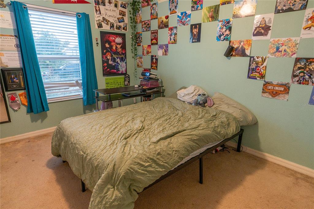 4563 Orchard Grove Road St. Cloud, FL 34772 - Photo 49 of 51 a bed sitting in a bedroom next to a window