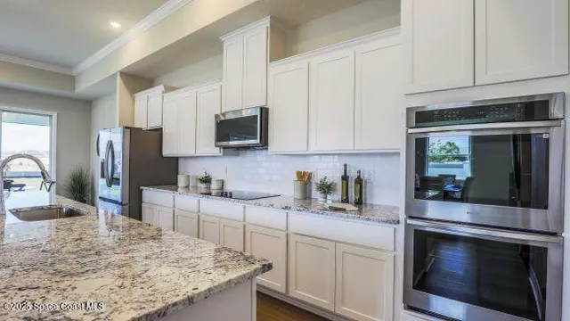 a kitchen with kitchen island granite countertop a stove a sink a dining table and chairs