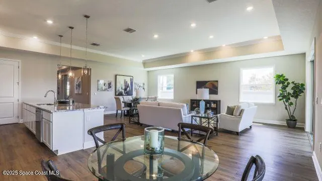 a room with white cabinets and couches with wooden floor