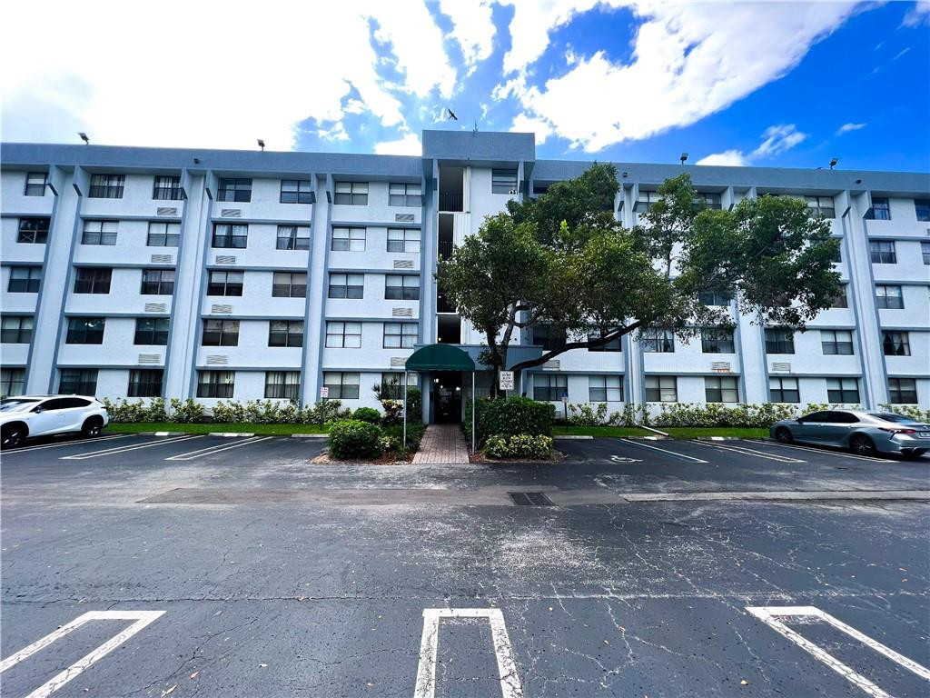 2401 Riverside Drive, Unit 309B Coral Springs, FL 33065 - Photo 1 of 9 a view of a building with a yard