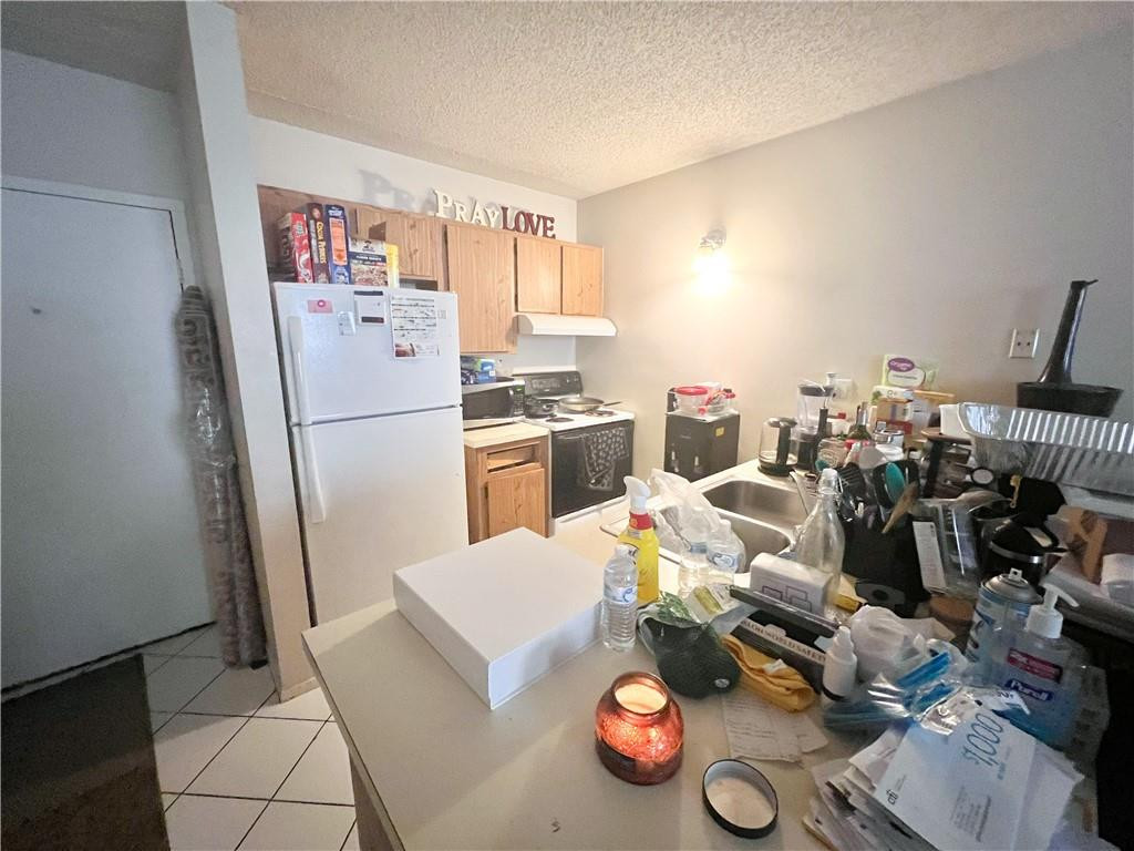 2401 Riverside Drive, Unit 309B Coral Springs, FL 33065 - Photo 5 of 9 a kitchen with refrigerator and wooden floor