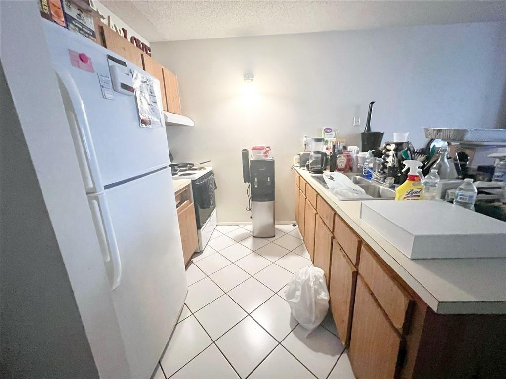 2401 Riverside Drive, Unit 309B Coral Springs, FL 33065 - Photo 6 of 9 a kitchen with a sink a refrigerator and a stove