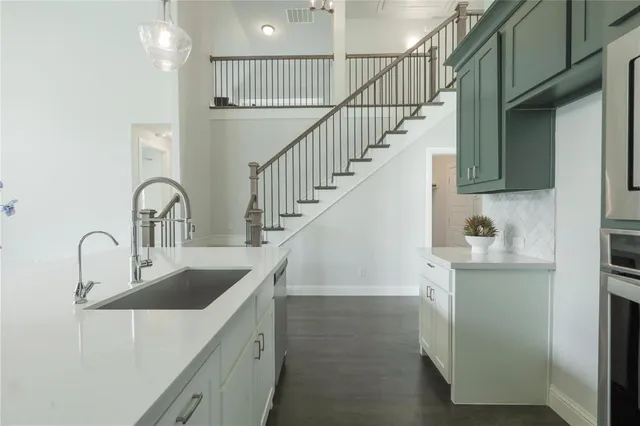 a kitchen with sink a refrigerator and cabinets