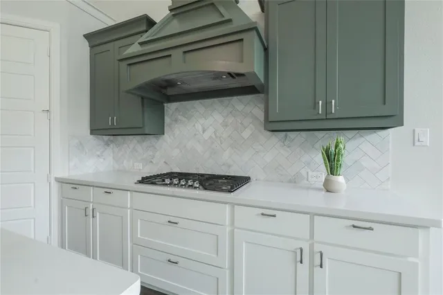 a kitchen with white cabinets and a stove